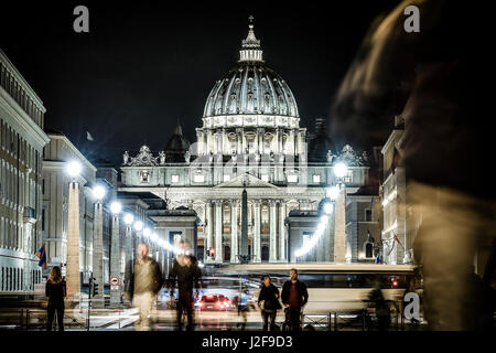 Blick auf den beleuchteten St. Peter Basilika, die Straße Via della Conciliazione und leichte Spuren von Autos in Rom, Italien Stockfoto