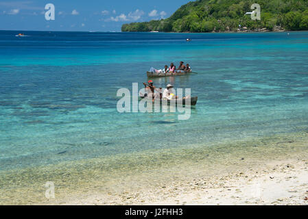 Melanesien, Salomon-Inseln, Santa Cruz Inselgruppe, Malo Insel. Klaren seichten Bucht und Korallen Riff, Dorfbewohner in typischen hölzernen Einbaum. (Großformatige Größen erhältlich) Stockfoto