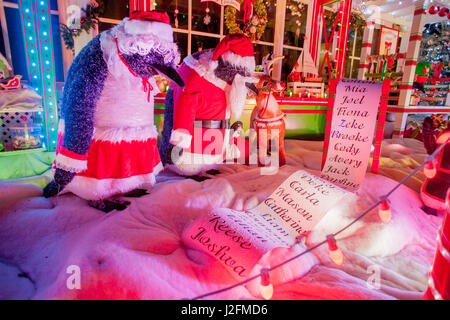 Ein reichhaltiges Weihnachtsfest anzeigen auf ein Haus in Newport Beach, CA, Funktionen eine Spielzeug-Werkstatt besetzt mit kostümierten Pinguine Inspektion einen Wunschzettel für Weihnachten. Stockfoto