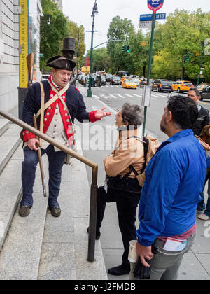 In der Uniform eines kontinentalen Soldaten in der amerikanischen Revolution, erklärt Dozent am New-York Historical Society Museum in New York City eine aktuelle Ausstellung über die Revolution den Passanten am Central Park West. Stockfoto