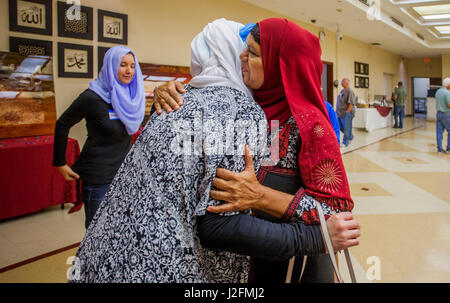 Tragen Hijab oder Kopf Schals, umarmen zwei muslimische Frauen im Nahen Osten Trachten nach Freitag Gottesdienste in einer Moschee in Anaheim, CA. Stockfoto