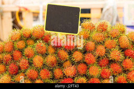 Rambutan mit Banner zu verkaufen hautnah Stockfoto