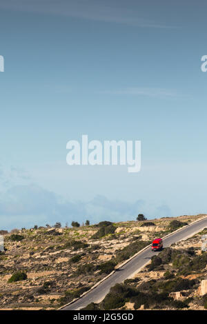 Einen roten Minivan fahren auf einem Hügel in der maltesischen Landschaft, etwas außerhalb von Mellieha. Malta, 8. Januar 2017 Stockfoto