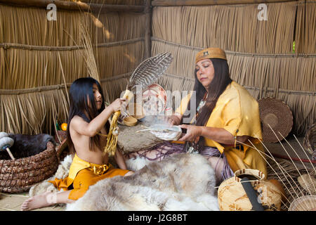 Acjachemen Nation (San Juan Capistrano Mission Indianer) zweifellos medizinische Tradition an ihren Enkel. Verbrennung von getrockneten weißen Salbei, Abalone-Muschel und ein Feder-Flügel-Fan, den medizinischen Rauch innerhalb einer traditionellen Tule Reed Tierheim zu verteilen. Stockfoto