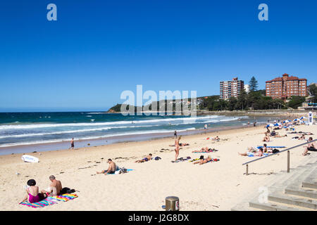 Menschen, die an einem heißen Sommertag am Manly Beach Sonnenbaden Stockfoto