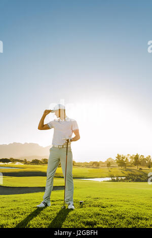 Gesamte Länge der junge Mann auf Golfplatz. Profi-Golfer Golf Club auf Feld halten. Stockfoto