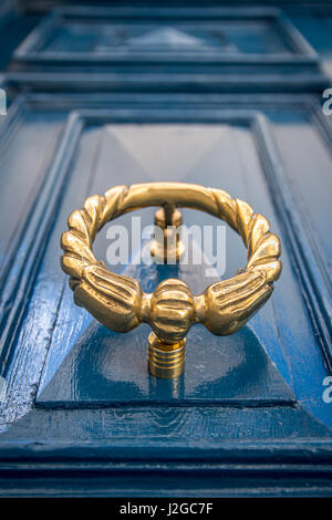 Antik gold oder Messing Türklopfer an einer blau lackierten Tür. Altes Stadthaus in Sliema, Malta. Stockfoto