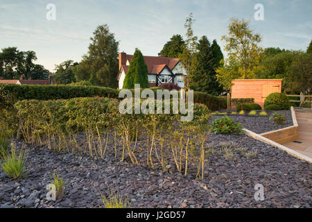 Schönen, privaten Garten, Yorkshire, England, UK - stilvolles, modernes Design, harte Landschaftsbau (Pflaster) Schuppen & neue Pflanzen auf Holz Hochbeete. Stockfoto