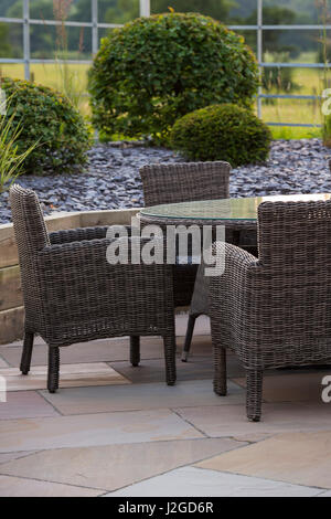 Schön, privat, modern gestalteten, Garten, Yorkshire, England, UK - Schanigarten (Patio-Möbel) durch erhöhte Grenze & topiary Sträuche. Stockfoto