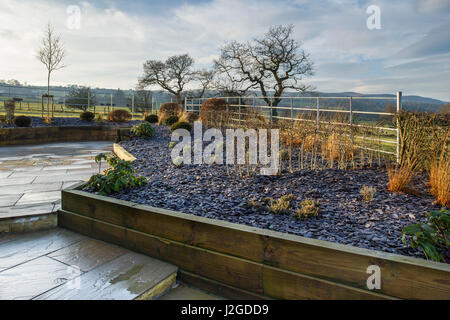 Wintersonne auf schönen, privaten Garten, Yorkshire, England, UK - stilvolles, modernes Design, schwer Landschaftsbau & Neuanpflanzungen auf Holz Hochbeete. Stockfoto