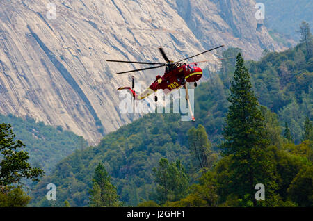 USA, California, El Portal, S-64 Skycrane Hubschrauber nehmen Wasser aus Merced River gegen Waldbrand Stockfoto