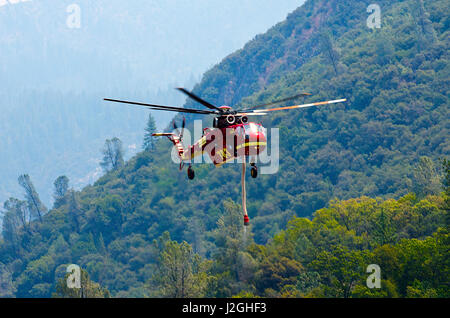 USA, California, El Portal, S-64 Skycrane Hubschrauber nehmen Wasser aus Merced River gegen Waldbrand Stockfoto