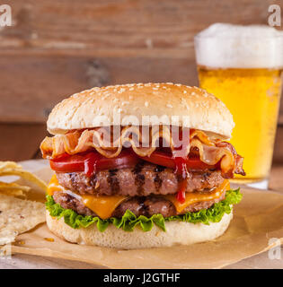 Speck und Käse Burger mit gegrilltem Rindfleisch Patty. Tomaten und Zwiebeln Stockfoto