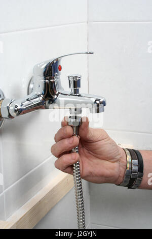 Klempner reparieren einen Wasserhahn im Badezimmer Stockfoto