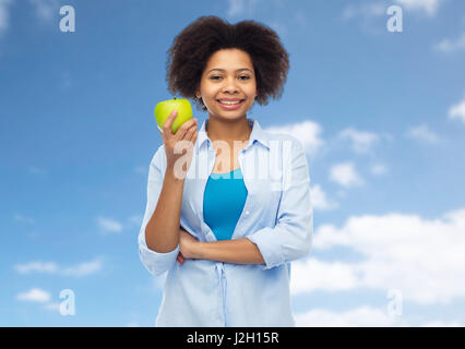 glückliche afroamerikanische Frau mit grünem Apfel Stockfoto