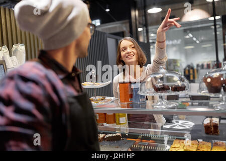 glückliche Frau, die etwas zu Barkeeper im café Stockfoto