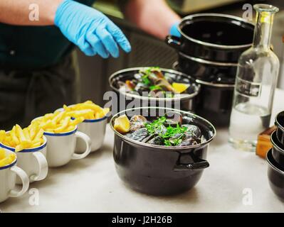 Pommes Frites mit Fisch und Meeresfrüchte am Steintisch. Muscheln und Garnelen. Ansicht von oben Stockfoto