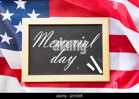 Gedenktag Wörter auf der Tafel und amerikanische Flagge Stockfoto