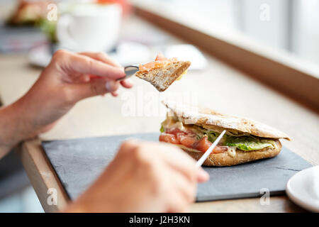 Frau essen Lachs Panini Sandwich Restaurant Stockfoto