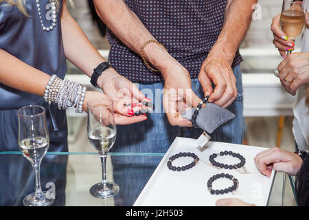 Frauen versuchen auf Armbänder und Schmuck bei einem Juwelier Stockfoto