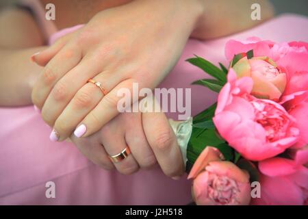 Frau mit einem Blumenstrauß umarmt ihr Ehemann Stockfoto