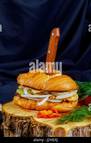 leckere Hähnchen-Sandwich mit Zwiebel Tomaten Gurke auf einem Holzständer-Tischplatte Stockfoto