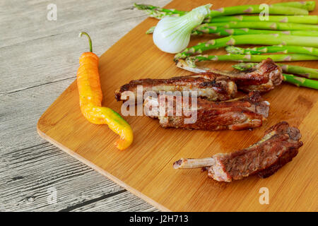 Nahaufnahme der Grill Ribs mit Pommes Frites und Soße auf einem alten Holztisch Stockfoto