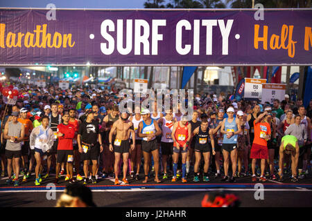 Gemischtrassig Marathon erste Hitze Teilnehmer versammeln sich in frühen Morgen an der Startlinie in Huntington Beach, Kalifornien, umgangssprachlich bekannt als "Surf City." Stockfoto