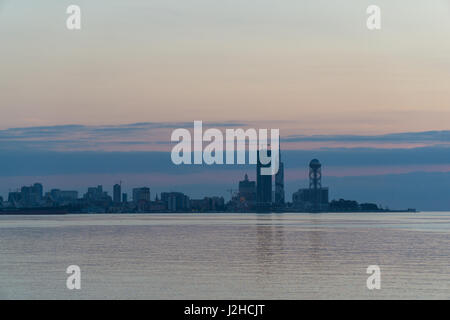 Batumi bei Sonnenuntergang. Blick vom Strand zum Stadtbild mit moderner Stadtarchitektur Wolkenkratzer. Adscharien, Georgia. Stockfoto