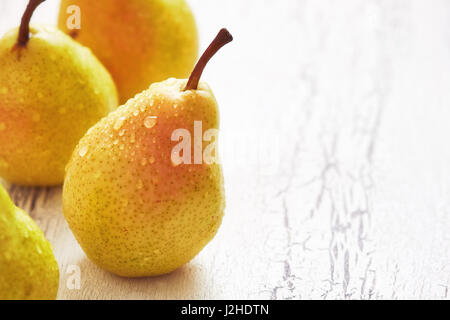 Frische Williams-Birnen (Bartlett Birne) auf weißem rustikalen Hintergrund. Textfreiraum Stockfoto