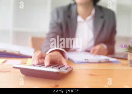 Geschäftsfrau, die Verwendung eines Taschenrechners, um die Zahlen zu berechnen. Buchhaltung, Rechnungswesen, Berechnung Konzept. Stockfoto