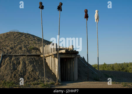 Rekonstruierte Medicine Lodge mit traditionellen heiligen Medizin Bundles gefüllt mit Mais auf montiert auf Stangen am Eingang bei auf-A-schräge Indian Village, South Dakota Stockfoto