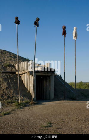 Rekonstruierte Medicine Lodge mit traditionellen heiligen Medizin Bundles gefüllt mit Mais auf montiert auf Stangen am Eingang bei auf-A-schräge Indian Village, South Dakota Stockfoto