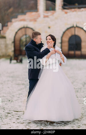 Winter Hochzeit Porträt. Liebevolle junge Bräutigam seine charmante Frau Gesicht sanft berühren Stockfoto