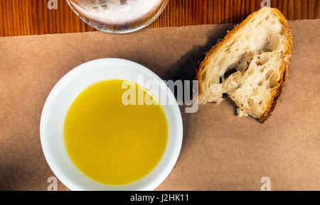 Olivenöl in einem Dip Schale und ein Stück italienisches Landbrot Stockfoto