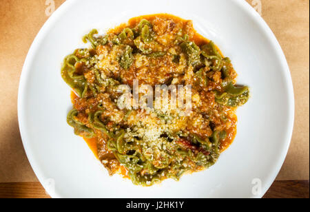 Mafaldine Spinat Pasta mit einem herzhaften Fleisch Ragout und Parmesankäse Stockfoto