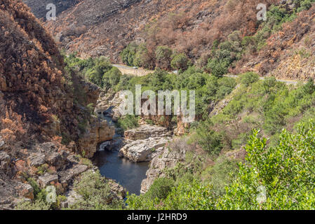 Ein Fluss und verbrannten Bergseite in den Tradouw Pass zwischen Barrydale und Swellendam in der Provinz Western Cape Stockfoto