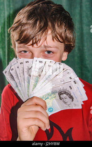 Junge mit Haufen von alten fünf-Pfund-Noten Stockfoto