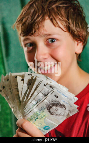 Junge mit Haufen von alten fünf-Pfund-Noten Stockfoto