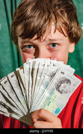 Junge mit Haufen von alten fünf-Pfund-Noten Stockfoto