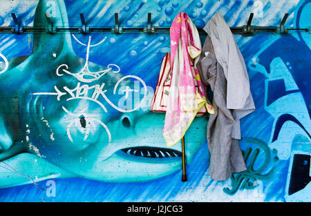 Ankleidezimmer mit hängende Kleidung vor Hai Graffiti befindet sich am Ufer des Genfer Sees bedeckt Stockfoto