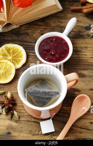 Jasmin-Tee in Keramik Krug auf Holztisch steht. Herbstliche Dekorationen rund um. Stockfoto