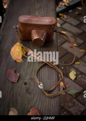 Vintage-Kamera auf Holzbank im Herbst Park. Stockfoto