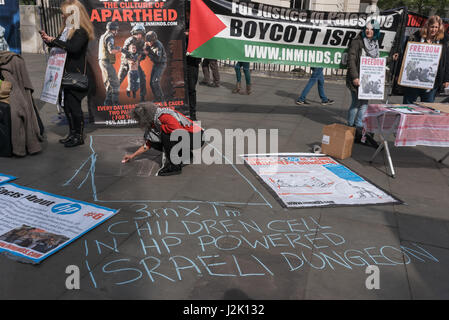 London, UK. 28. April 2017. London, UK. 28. April 2017. Eine Frau Kreide eine Abbildung eines Kindes zeigt die Größe der unterirdischen Zellen, die sie in einsamen Confinnemnet in israelischen Gefängnissen sitzen, laufen, mit HP-Hardware und Software gehalten werden. Tye Vigil von Inminds menschliche Recht-Gruppe am Rande des Trafalgar Square gaben Informationen und stand in Solidarität mit den größten Hungerstreik palästinensischer politischer Gefangener in 5 Jahren. Mehr als 1500 palästinensische Gefangene aus allen Fraktionen ging im Hungerstreik am 17. April 2017 und mehr haben seit trotz brutalen Angriffe durch Wärter und Zwangsernährung. T Stockfoto