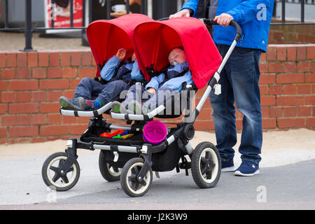 Einzelperson, Vater Rollen Kinderwagen Baby carraige Kinderwagen in Lytham St Annes, Lancashire, Großbritannien. April 2017. Wetter in Großbritannien. Warme Winde und leichte Duschen, während Touristen in den unberührten Sand von Lytham fahren, um das Feiertagswochenende zu genießen. Der preisgekrönte Strand ist ein Paradies für Touristen und Urlauber und wird für eine Vielzahl von Aktivitäten genutzt. Der Strand in St. Annes an der Fylde-Küste ist eine riesige Fläche aus goldenem Sand; perfekt zum herumlaufen und Sandburgen bauen. Kredit; MediaWorldImages/AlamyLiveNews Stockfoto