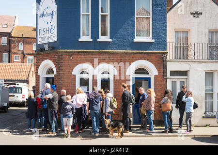 Aldeburgh Suffolk UK, 29. April 2017. Menschen in die Warteschlange für Fish And Chips außerhalb der berühmten Aldeburgh Fish and Chip Shop bei strahlendem Sonnenschein und Temperaturen von 13 Grad Celsius auf der Bank Holiday WeekendCredit Julian Eales/Alamy Live News Stockfoto