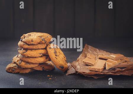 Schokoladenkekse auf dunklem Hintergrund, frisch aus dem Ofen bei schwachem Licht Stockfoto