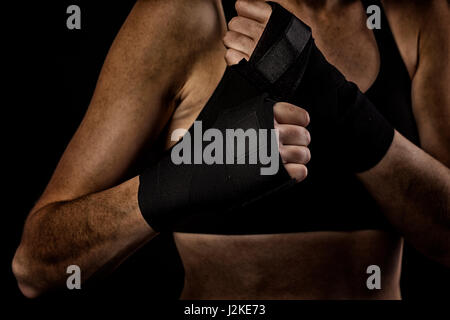 Boxerin, die Hände mit Boxen Klebeband umwickeln Stockfoto