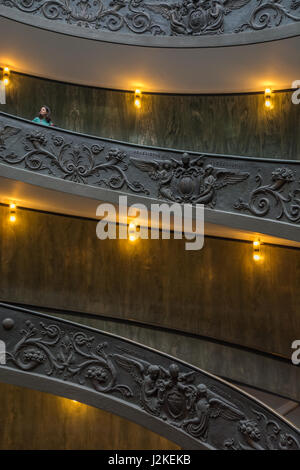 Ein Tourist wartet auf den Stufen der Bramante-Treppe am Ausgang zur Sixtinischen Kapelle und zum Vatikanischen Museum in Rom, Italien Stockfoto