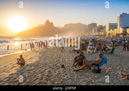 RIO DE JANEIRO - 28. Januar 2017: Beachgoers genießen einen klaren Himmelsblick auf Sonnenuntergang von Arpoador Ende der Strand von Ipanema. Stockfoto